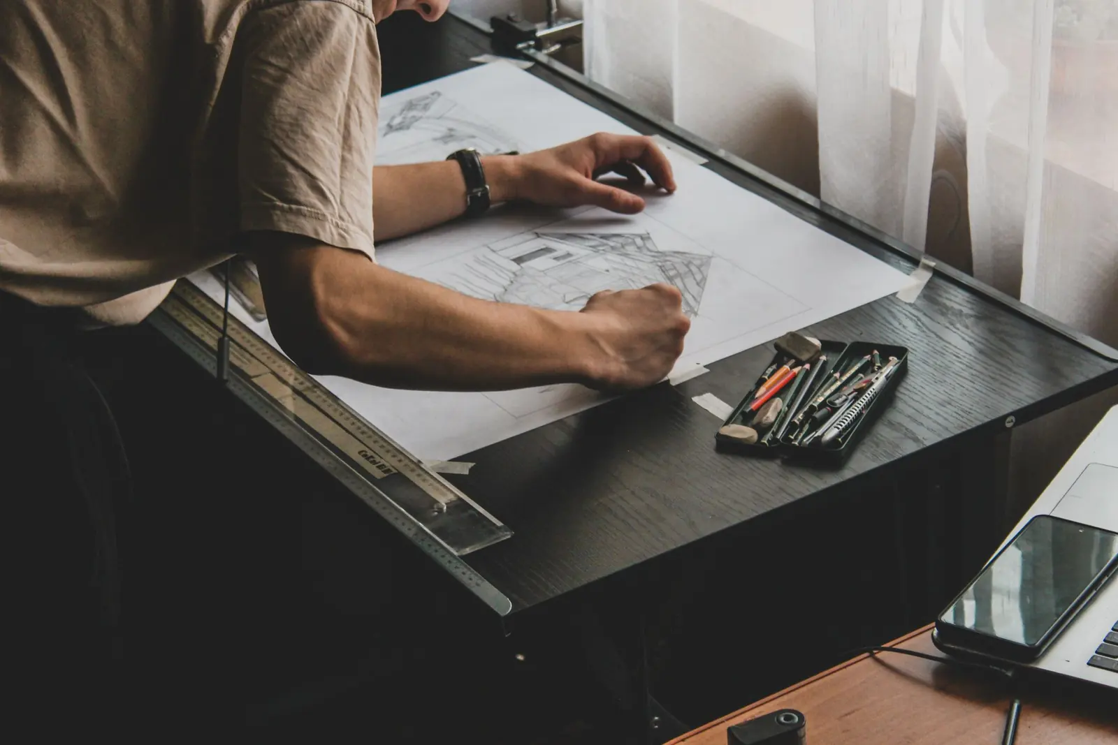 Arquiteto desenhando um projeto à mão sobre a prancheta
